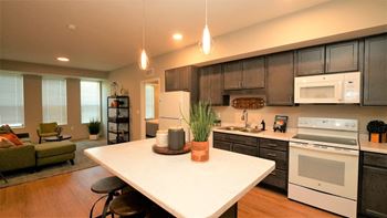 a kitchen and living room with a white counter top
